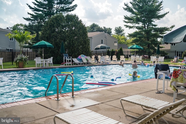 community pool with a patio and fence