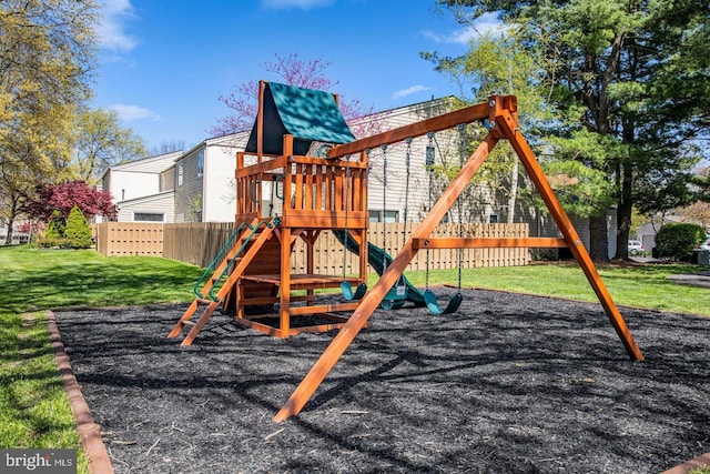 view of playground with a lawn and fence