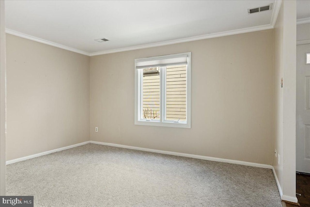 unfurnished room with crown molding, carpet flooring, baseboards, and visible vents