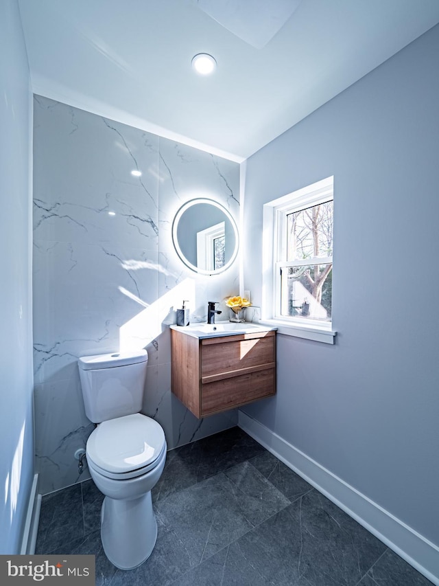 bathroom featuring vanity, toilet, and baseboards