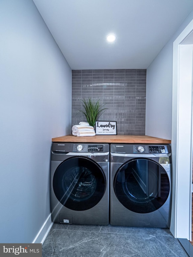 laundry room with washing machine and clothes dryer, laundry area, and baseboards