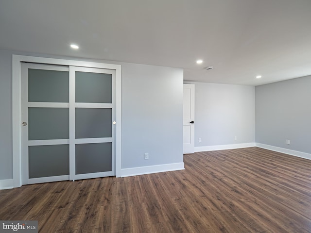 spare room with dark wood finished floors, recessed lighting, and baseboards