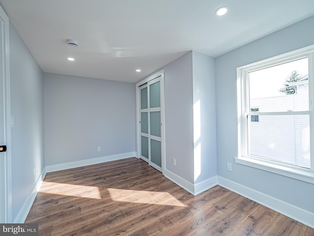 empty room with recessed lighting, baseboards, and wood finished floors