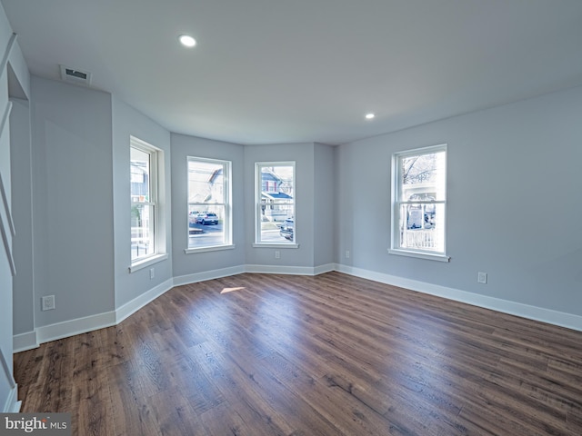 unfurnished room featuring dark wood finished floors, visible vents, recessed lighting, and baseboards