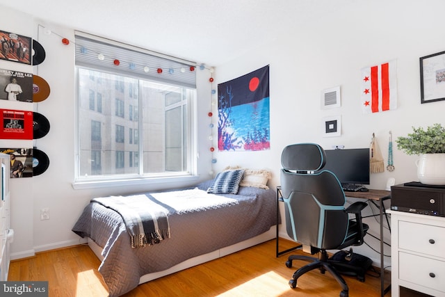 bedroom with visible vents, baseboards, and wood finished floors