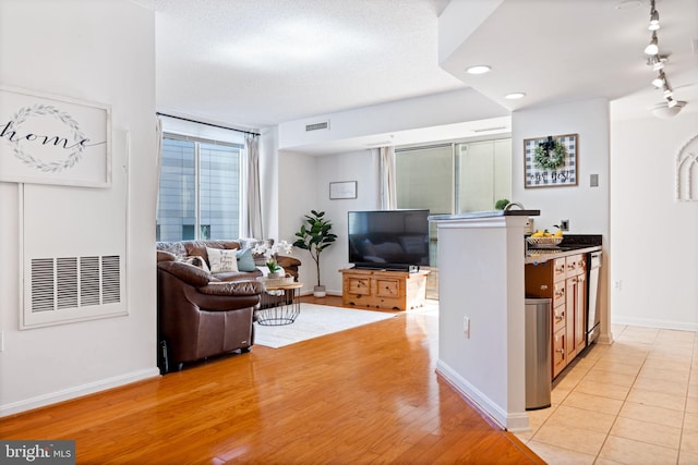 living area with baseboards, visible vents, recessed lighting, rail lighting, and light wood-type flooring