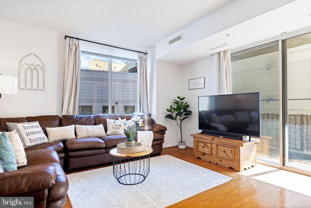 living room featuring visible vents and wood finished floors