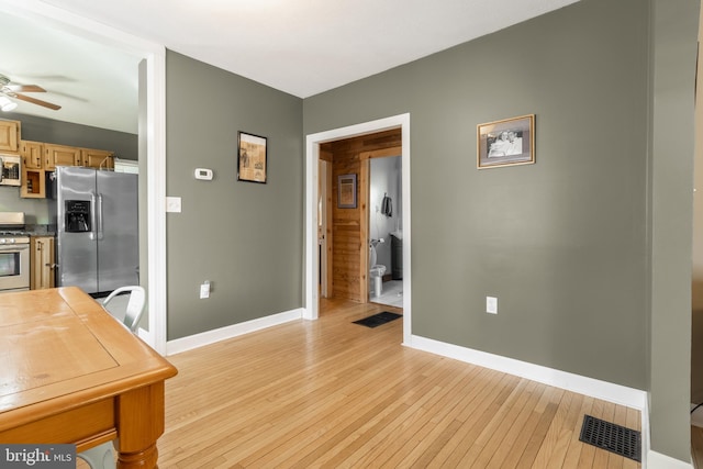 kitchen with light wood-type flooring, baseboards, visible vents, and stainless steel appliances