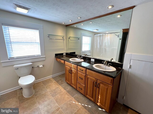 bathroom with a textured ceiling, visible vents, and a sink