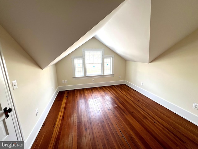 bonus room with baseboards, lofted ceiling, and hardwood / wood-style flooring