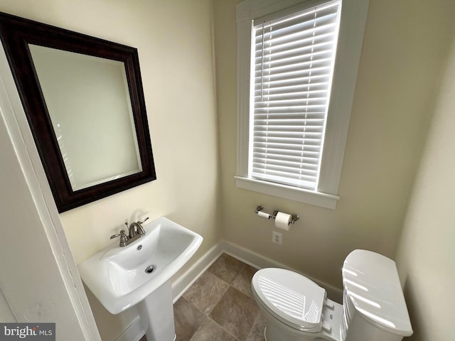 bathroom featuring toilet and baseboards