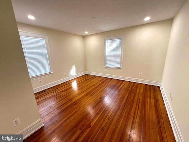 empty room featuring visible vents, recessed lighting, baseboards, and hardwood / wood-style flooring