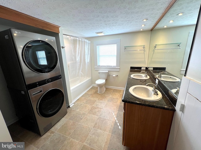 full bath featuring stacked washing maching and dryer, shower / tub combo with curtain, and a sink