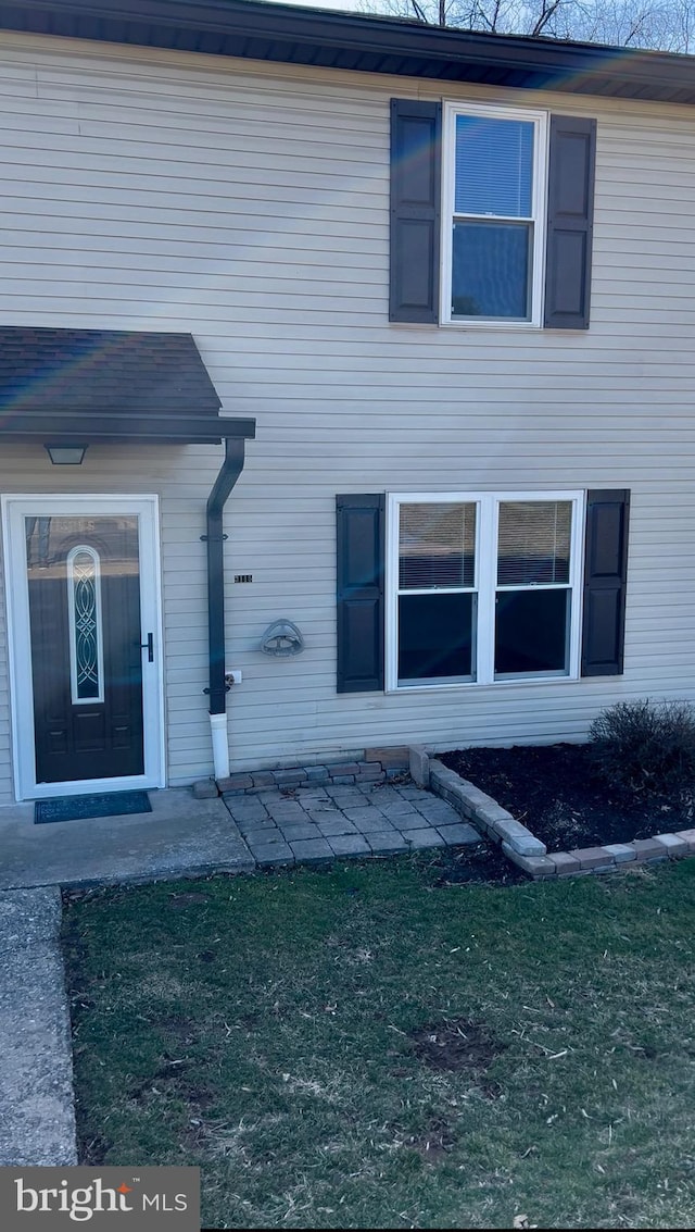 doorway to property featuring a yard and a patio