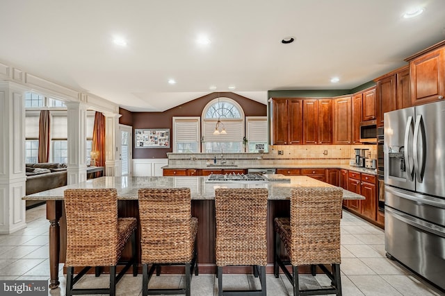 kitchen featuring light tile patterned floors, stainless steel appliances, and decorative columns