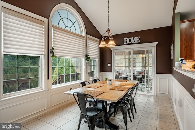 dining area featuring lofted ceiling, light tile patterned flooring, and a wealth of natural light