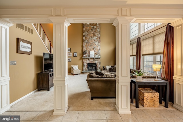 living area featuring visible vents, a healthy amount of sunlight, and decorative columns