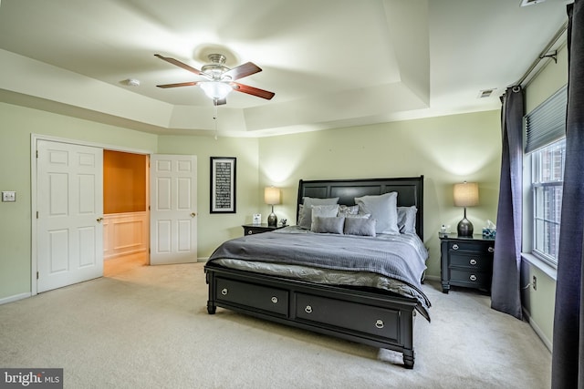 bedroom featuring visible vents, baseboards, carpet, a raised ceiling, and ceiling fan