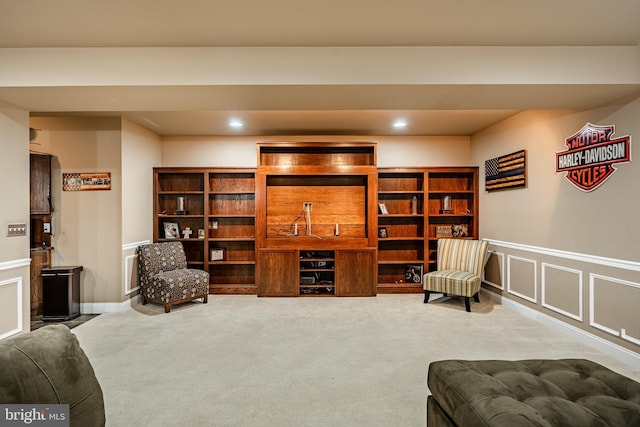 sitting room featuring recessed lighting, a decorative wall, wainscoting, and carpet