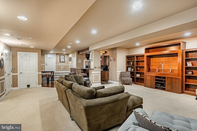 living room with recessed lighting, visible vents, baseboards, and light colored carpet