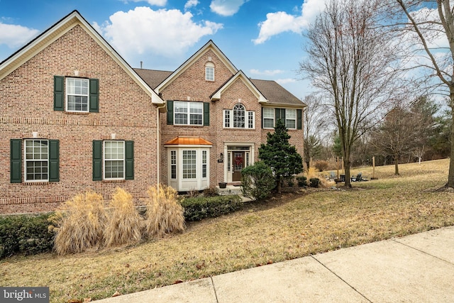 view of front of house featuring brick siding and a front lawn