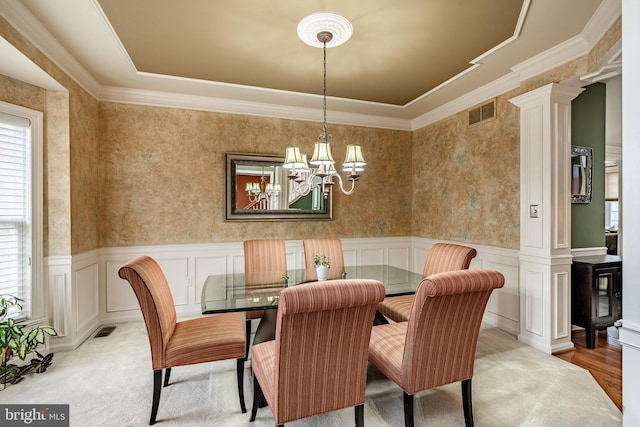 dining area featuring decorative columns, visible vents, and wainscoting