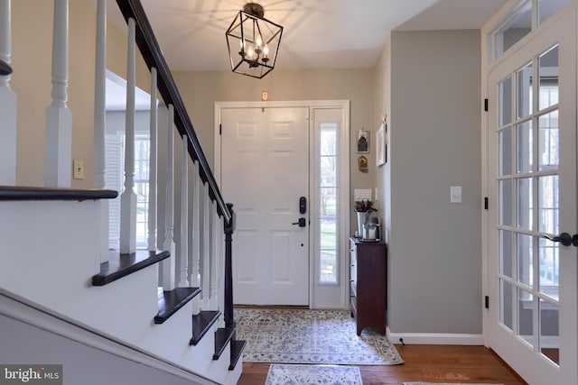 entryway featuring stairway, baseboards, and wood finished floors