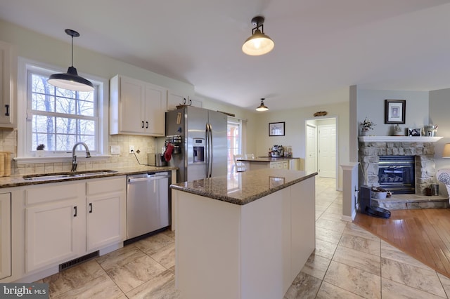 kitchen with visible vents, white cabinets, appliances with stainless steel finishes, and a sink