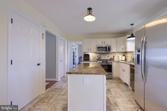 kitchen with tasteful backsplash, a center island, appliances with stainless steel finishes, white cabinets, and marble finish floor