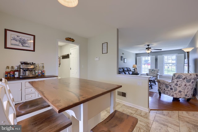 kitchen with white cabinetry, dark countertops, a ceiling fan, and visible vents