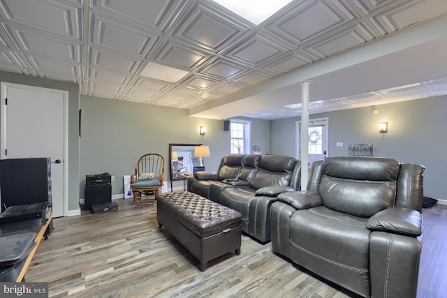 living area featuring light wood finished floors, baseboards, and an ornate ceiling