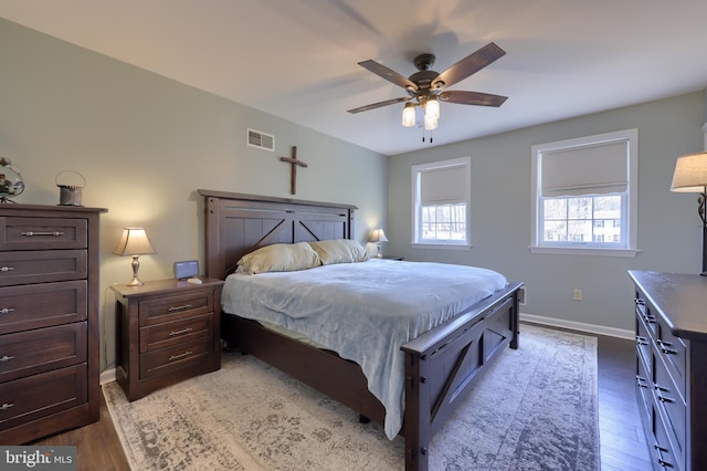 bedroom with visible vents, ceiling fan, baseboards, and wood finished floors