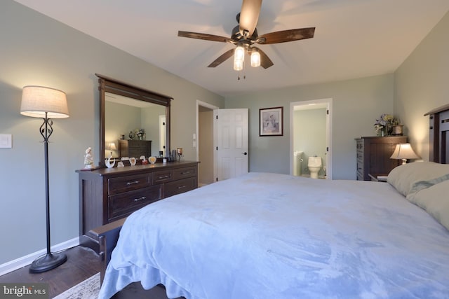 bedroom with dark wood finished floors, ensuite bath, baseboards, and ceiling fan