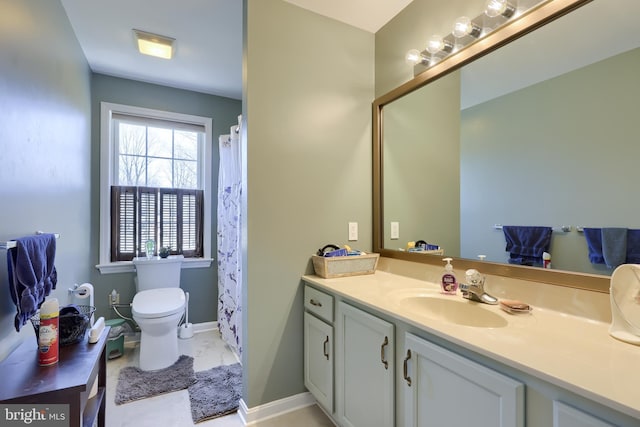 bathroom featuring toilet, vanity, and baseboards