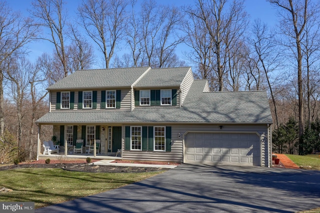 view of front of home featuring a porch, an attached garage, roof with shingles, and aphalt driveway