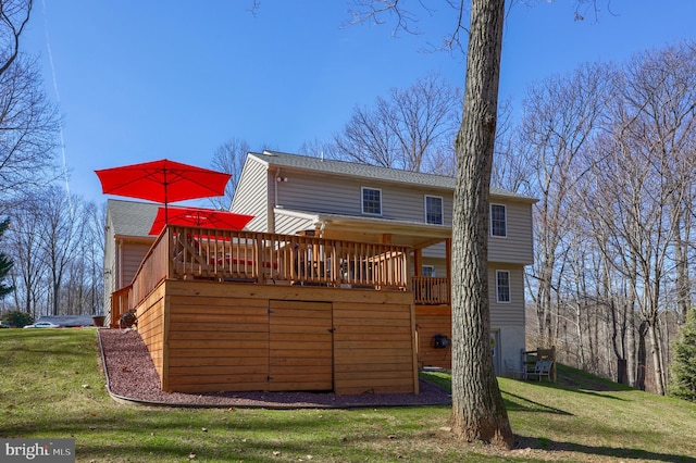 rear view of house with a lawn and a deck