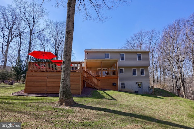 rear view of property featuring a deck, stairway, and a lawn