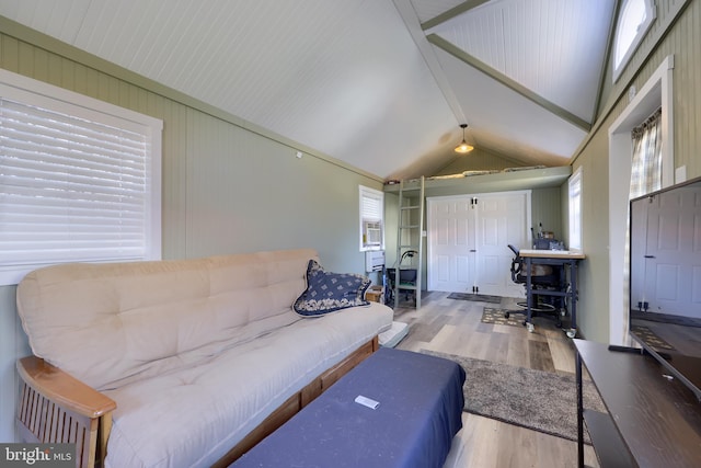 living area featuring lofted ceiling with beams and wood finished floors