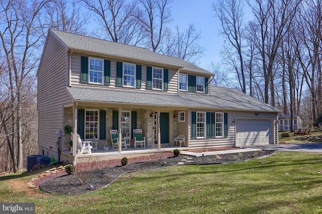 view of front of property with covered porch, a front lawn, a garage, stone siding, and aphalt driveway