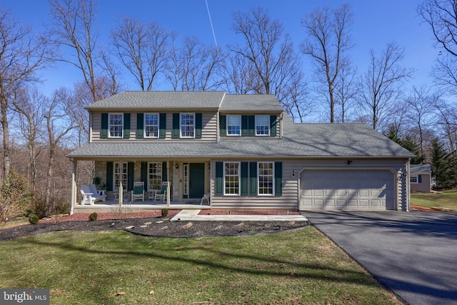 view of front of house featuring roof with shingles, a porch, an attached garage, a front lawn, and aphalt driveway