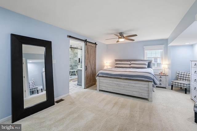 bedroom with a barn door, light colored carpet, visible vents, and baseboards