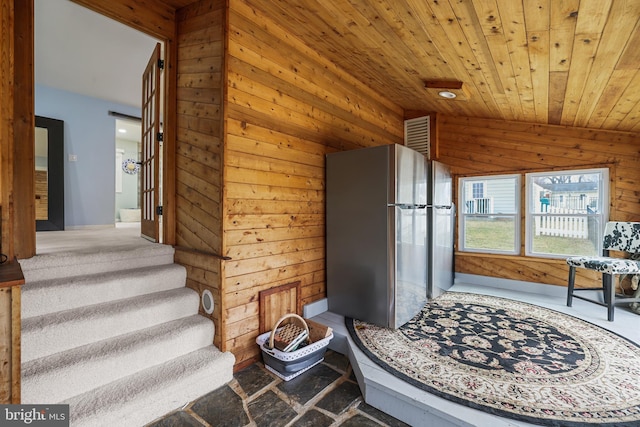 interior space with wood walls, wooden ceiling, and lofted ceiling