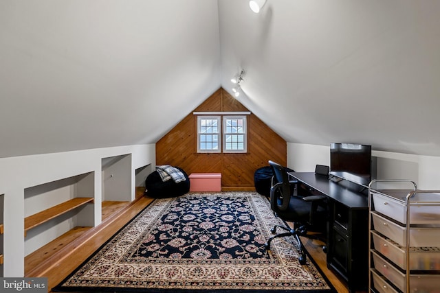 office featuring wooden walls, wood finished floors, and vaulted ceiling