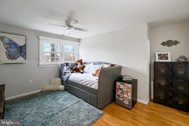 bedroom featuring visible vents, baseboards, wood finished floors, and a ceiling fan