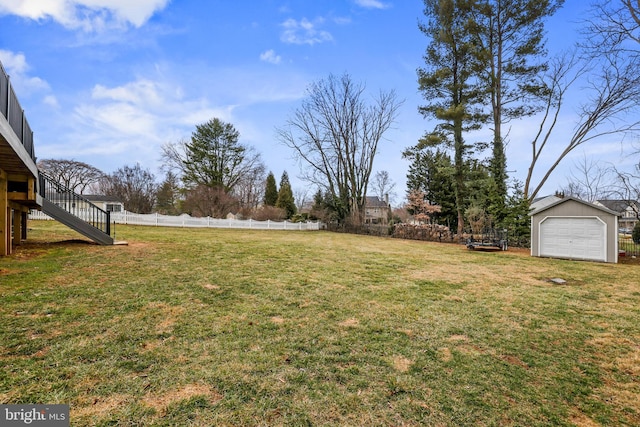 view of yard featuring an outbuilding, stairs, and fence