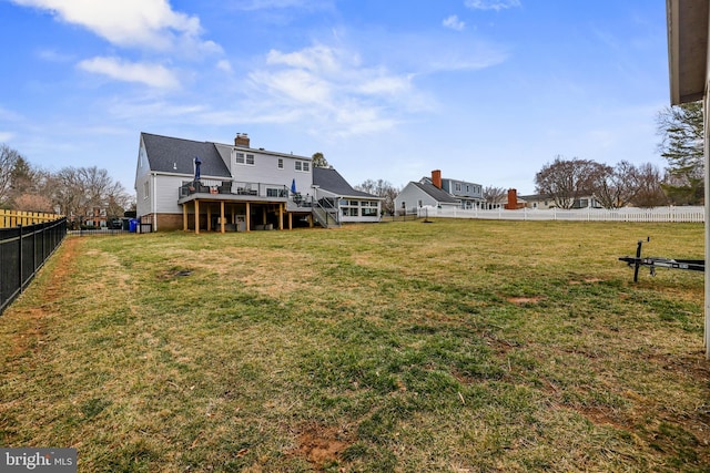 view of yard with a wooden deck, a fenced backyard, and stairs