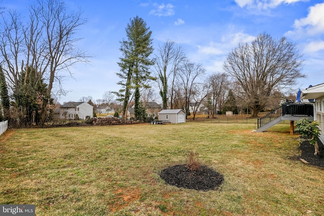 view of yard with an outbuilding, a fenced backyard, and a shed