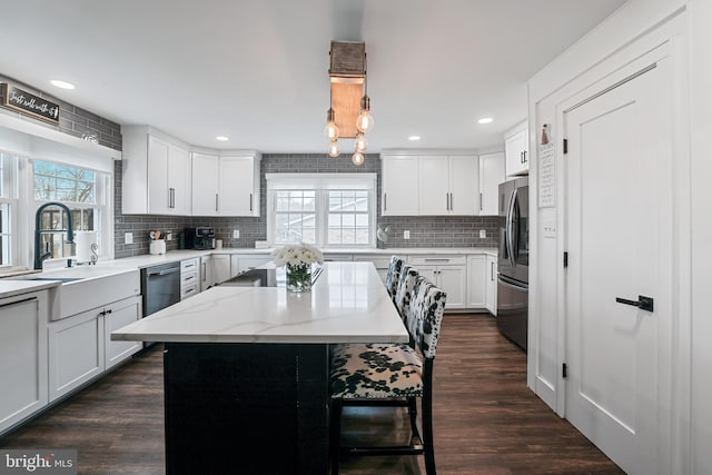 kitchen featuring dark wood finished floors, a kitchen island, white cabinets, and stainless steel appliances