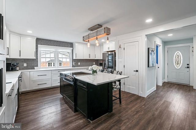 kitchen with dark wood-type flooring, a kitchen breakfast bar, smart refrigerator, white cabinets, and black electric range oven