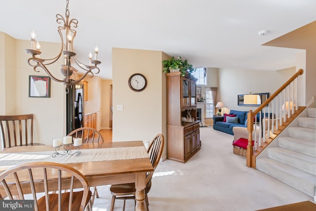 dining room featuring light carpet, stairs, and an inviting chandelier